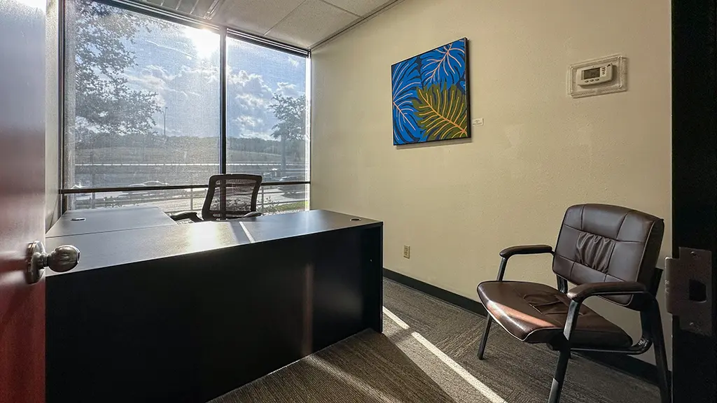Private office with window view and furnished workspace at Kinected Coworking San Antonio