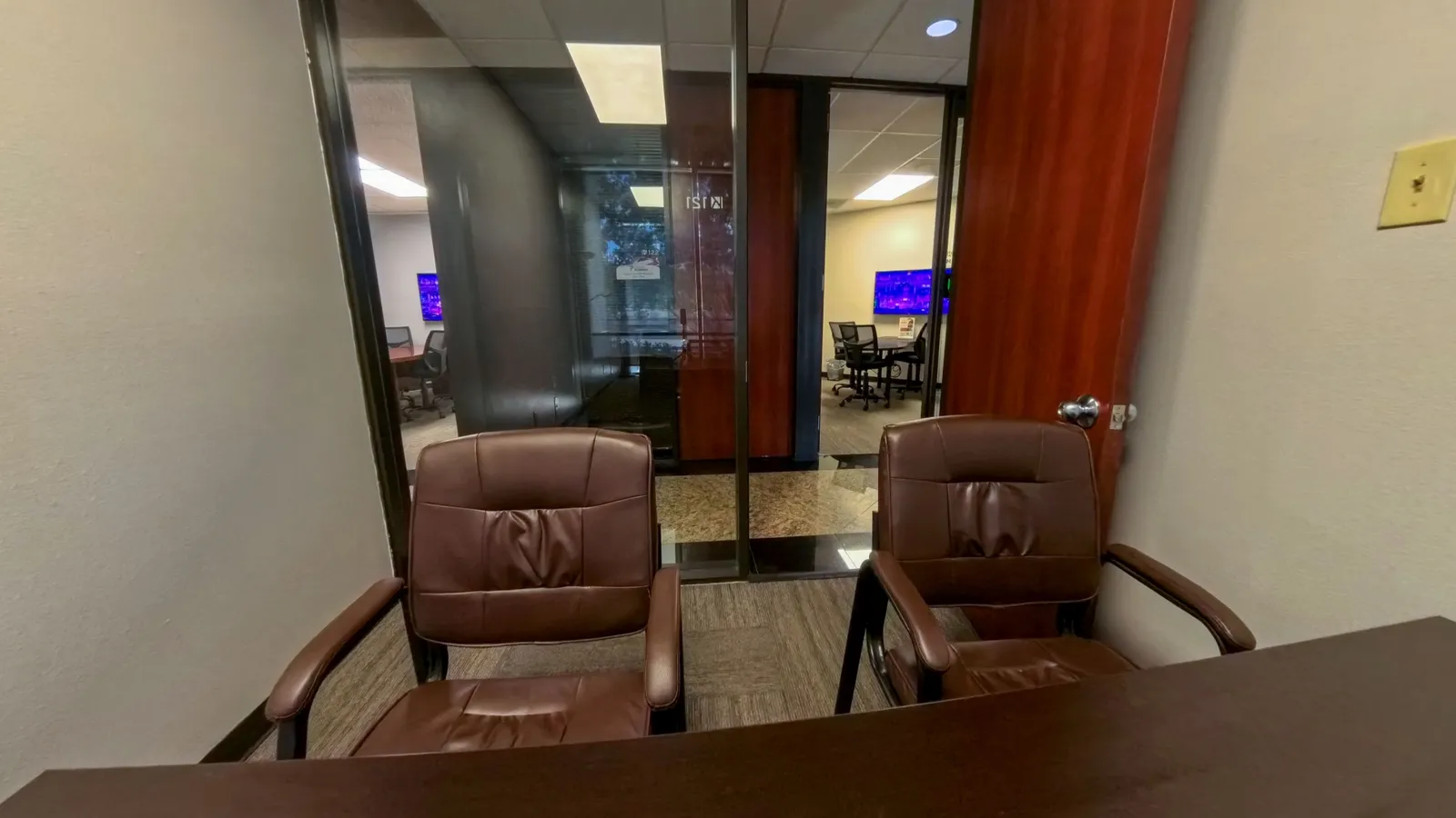 Interior of private Room 121 at Kinected Coworking with desk and guest chairs